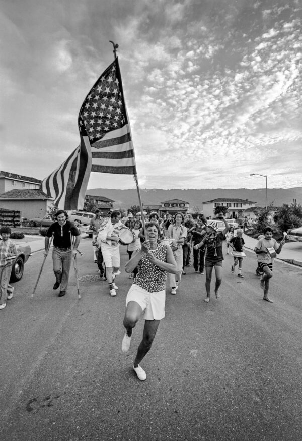 A picture of the people walking on the roads holding USA flag