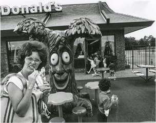 Woman with drink in front of McDonald's play park